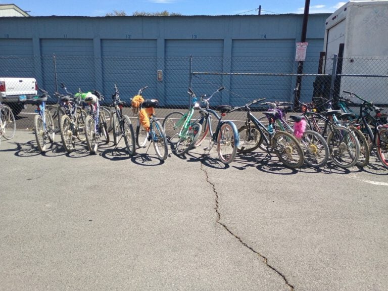 A row of decorated playa bikes parked at the storage units